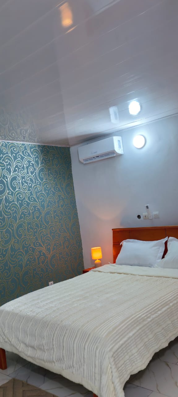 Chambre avec mur à motifs orientaux turquoise et couette blanche