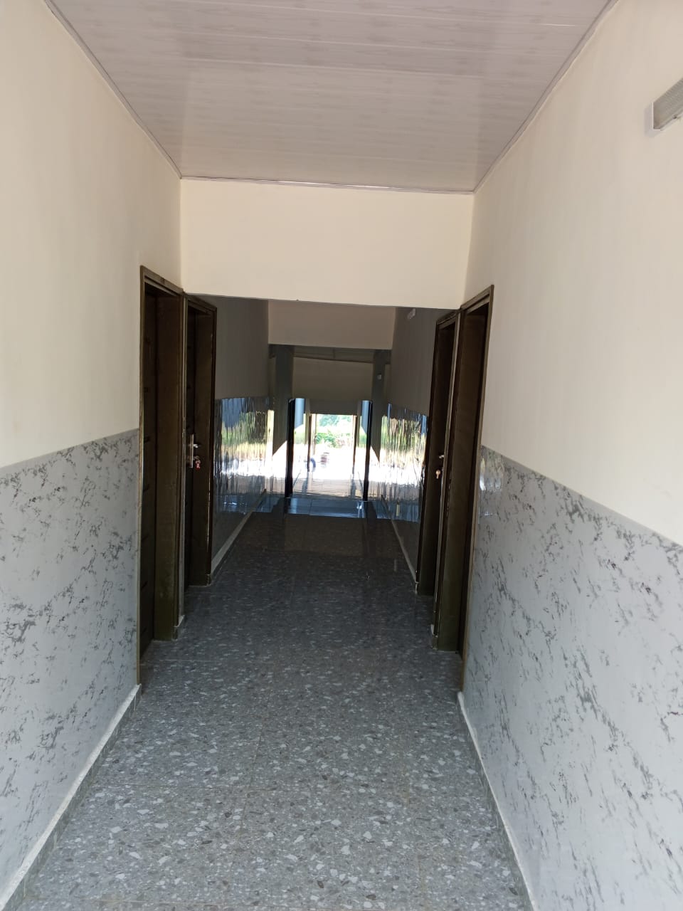 Couloir lumineux de l'Hôtel Békan Tié — ambiance matinale